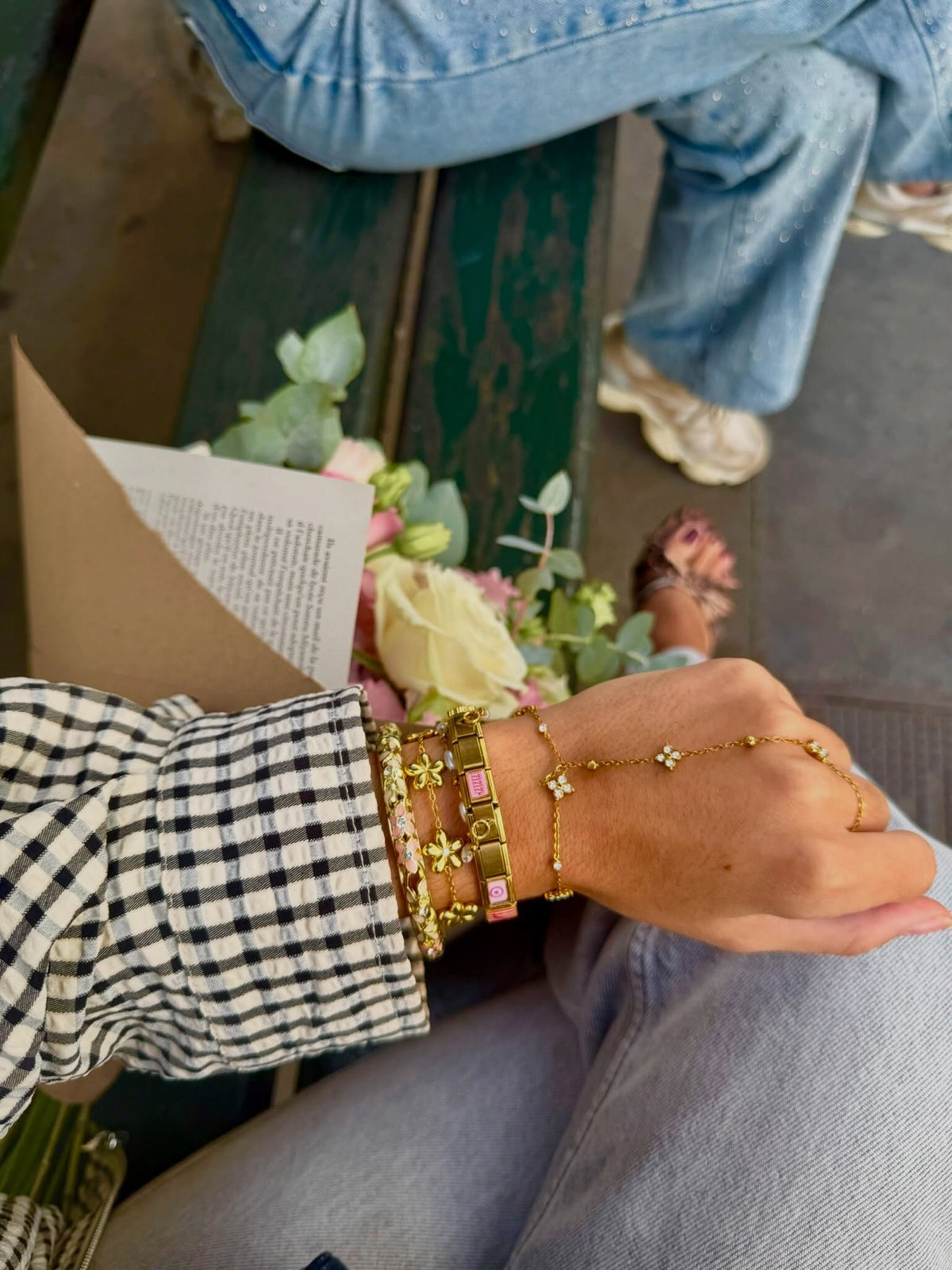 Bracelets à charms italiens dorés portés au poignet, en gros plan