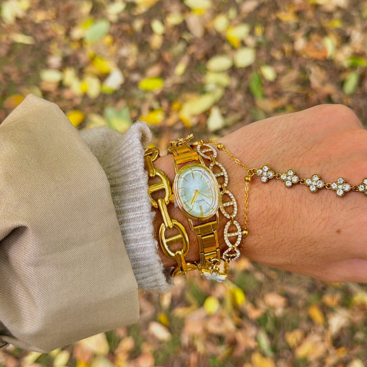 Bracelet Ange doré porté au poignet, maillons marine pavés de strass